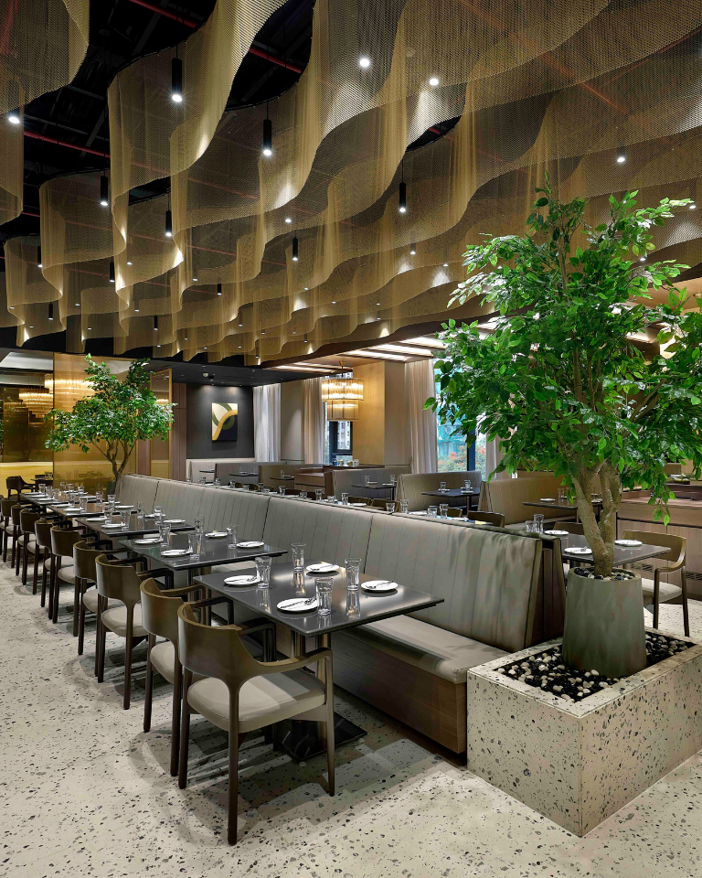 Interior of a modern restaurant with warm lighting and wooden furniture.